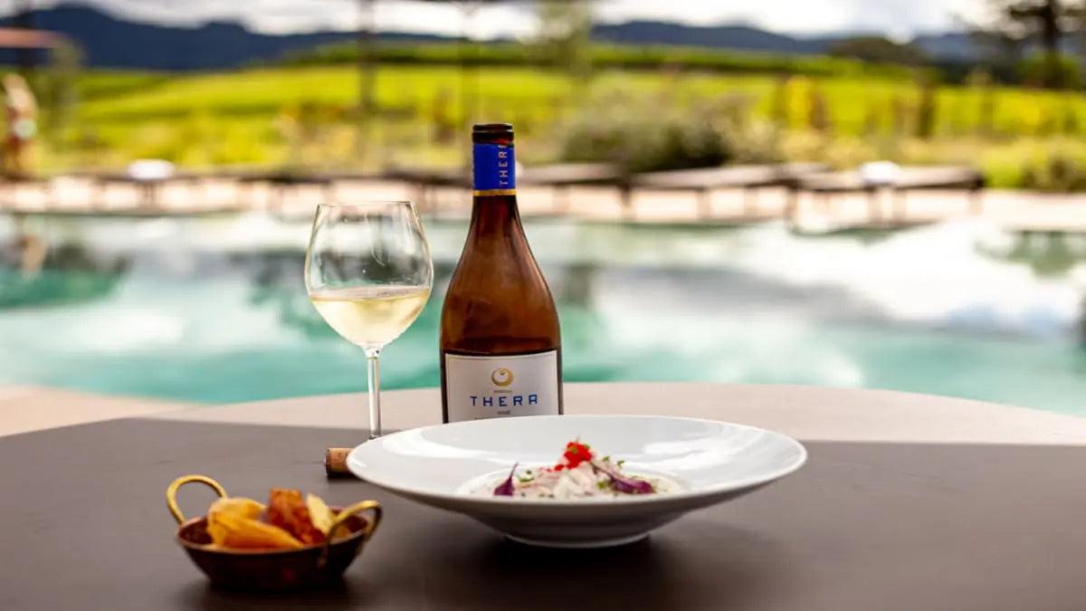 a imagem mostra um rótulo de vinho da Thera harmonizando com uma refeição.